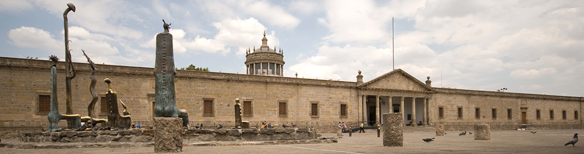 Foto de la fachada del Instituto Cultural Cabañas, del lado izquierdo una serie de esculturas de bronce llamada "Sala de los Magos" de Alejandro Colunga